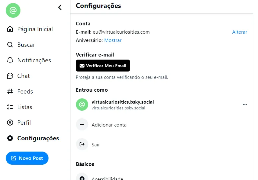 Uma página com o menu lateral: Página Inicial, Buscar, Notificações, Chat, Feeds, Listas, Perfil, Configurações (ativo), e o botão "Novo Post." Na parte central: Conta, e-mail: eu@virtualcuriosities.com. Aniversário: Mostrar / Alterar. Verificar -email: botão "Verificar Meu Email." Projeta a sua conta verificando seu e-mail. Entrou como: virtualcuriosities.bsky.social. Botão: Adicionar conta, Sair.