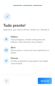 Uma página com o texto: Tudo pronto! Esperamos que você se divirta. Lembre-se o Bluesky é: Público, suas postagens, curtidas e bloqueios são públicos. Silenciamentos são privados. Abrir [sic], nunca perca o acesso aos seus seguidores ou dados. Flexível, escolha os algoritmos que geram seus feeds customizados. Com dois botões no rodapé: Voltar e "Vamos lá!"