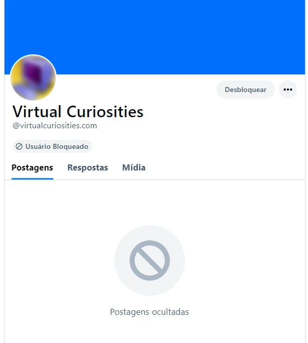 Uma página de perfil do Bluesky que diz "Usuário Bloqueado" sob o nome do usuário. Em vez de posts, a mensagem "Postagens ocultadas" é exibida. Há um botão "Desbloquear" no lugar no botão "Seguir." A foto de perfil do usuário aparece borrada.