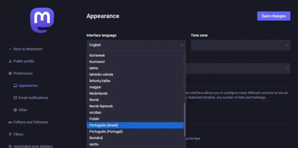 Uma página escura com o logotipo do Mastodon. No menu esquerdo os itens: Back to Mastodon, Public profile, Preferences, Appearance (ativo), Email notification, other, follow and followers, filters. O título da página é Appearance. Um campo rotulado "Interface Language" com um botão de lista suspensa com a opção "English" atualmente seleciona no botão, a opção "Português (Brasil)" selecionado na lista. No canto superio-direito, um botão rotulado "Save changes."
